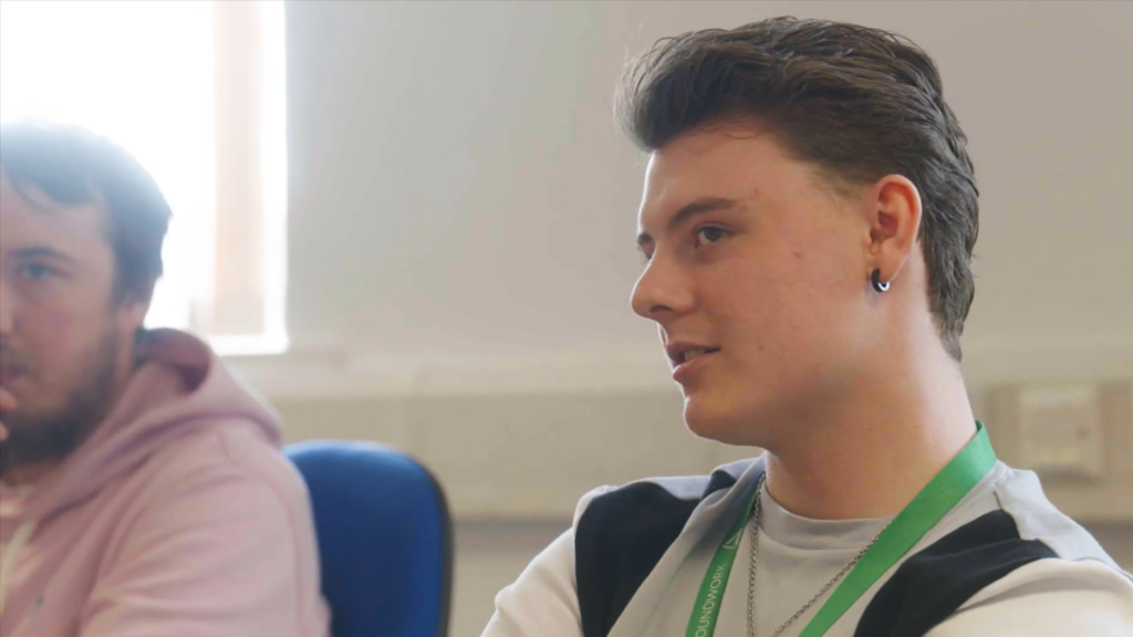 Connor Sitting in a room smiling to someone off camera