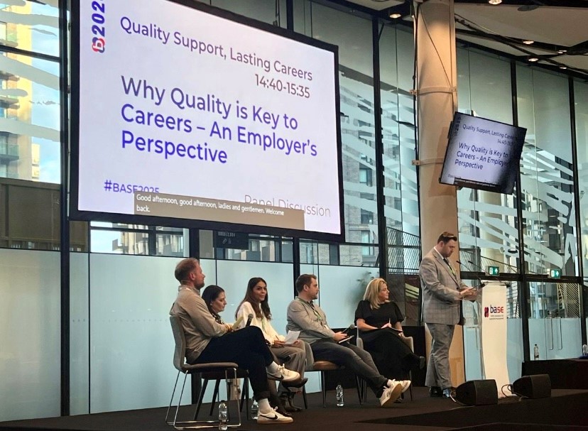 Ramsay Taylor and representatives from various companies sit below a screen that reads 'Why Quality is Key to Careers - An Employer's Perspective' 