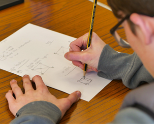 Young person writing on a sheet of paper