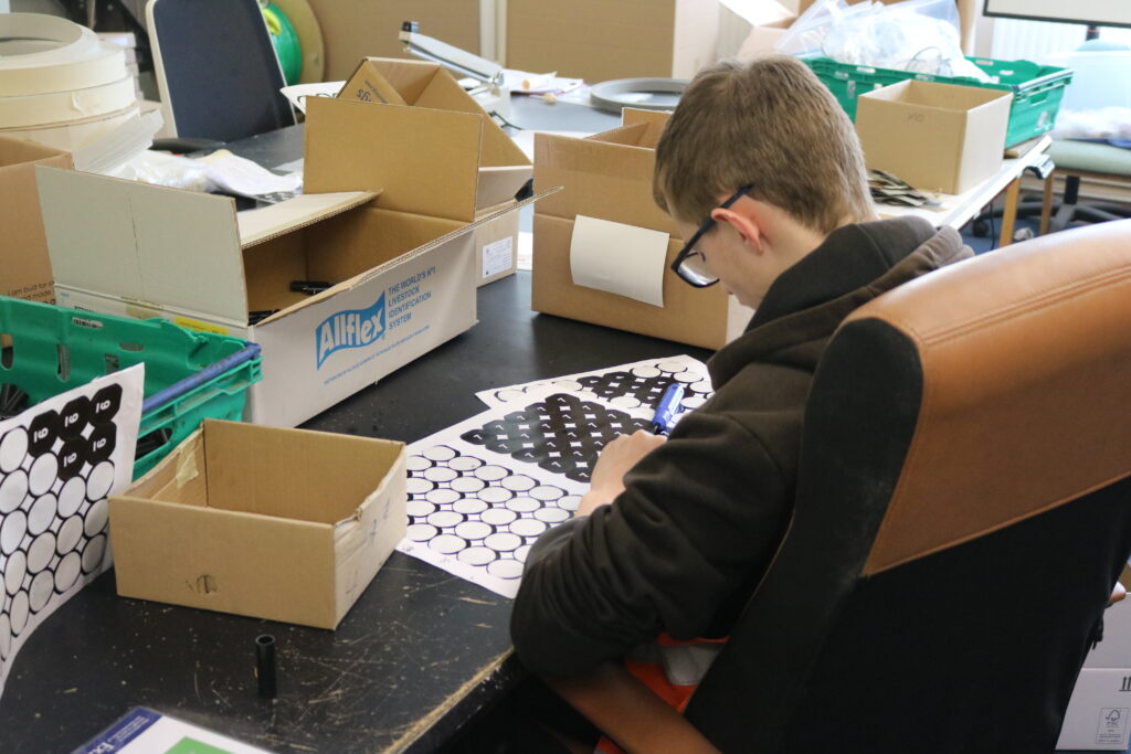 A younfg male sitting at a desk working.